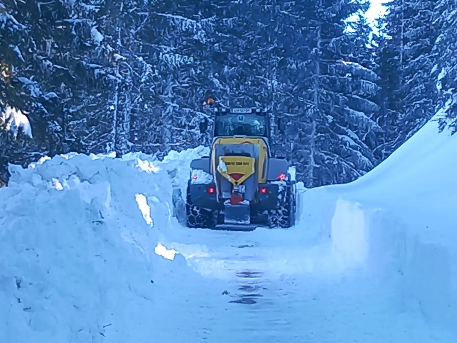 Winterdienst auf einem verschneiten Forstweg